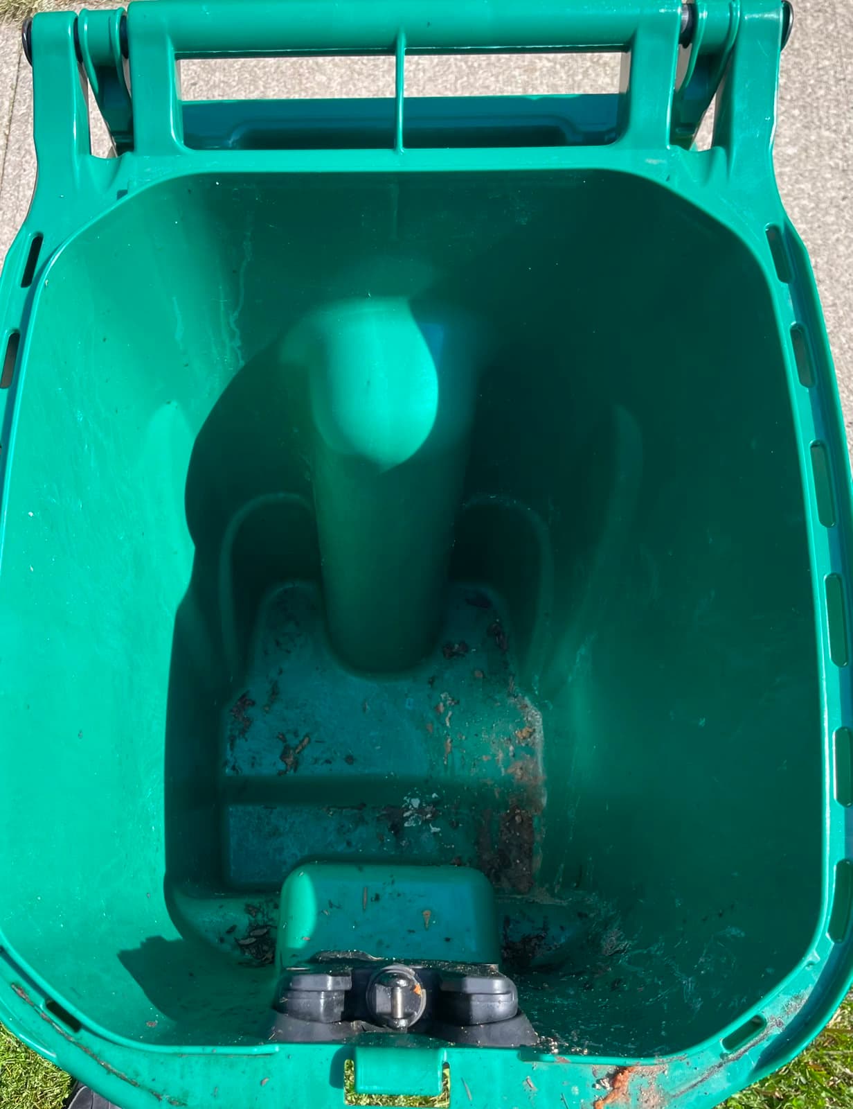 Dirty green garbage can before cleaning